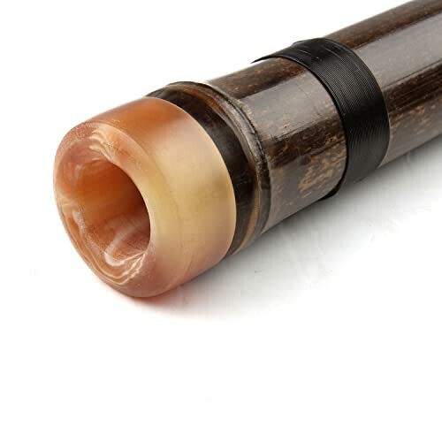 Close-up of a bamboo flute mouthpiece with a decorative band.