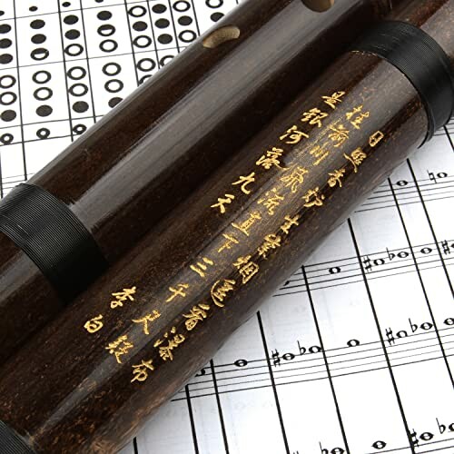 Chinese bamboo flute on top of music sheets with Chinese characters.