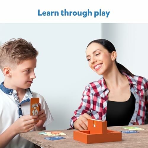 Child and adult playing a card game at a table.