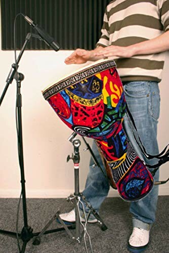 Person playing a colorful djembe drum next to a microphone stand.